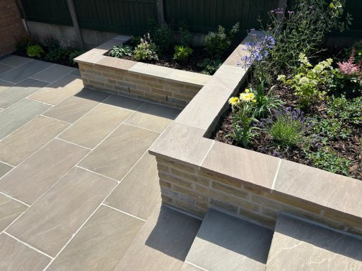Natural sandstone patio with Yorkstone raised borders and walling completed in Ashton In Makerfield, Wigan.